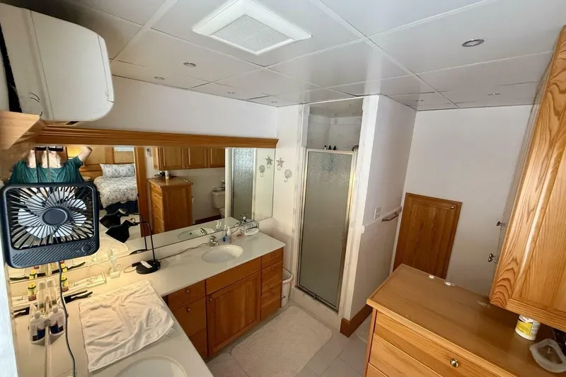Slide: The Image of Luxurious bathroom in 2018 Avenger Custom Catamaran, featuring wood cabinetry and modern amenities. - 24