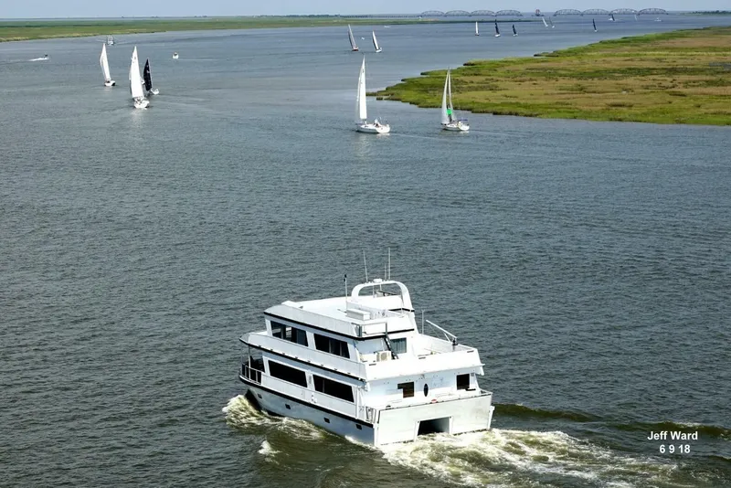 Slide: The Image of 2018 Avenger Custom Luxury Catamaran cruising coastal waters with sailboats nearby. - 3