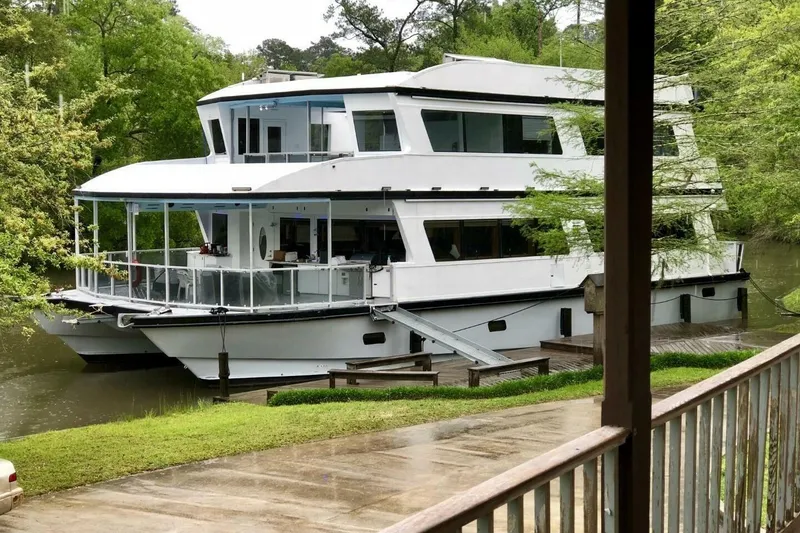 Slide: The Image of 2018 Avenger Custom Luxury Catamaran Coastal Cruiser docked by lush greenery. - 5