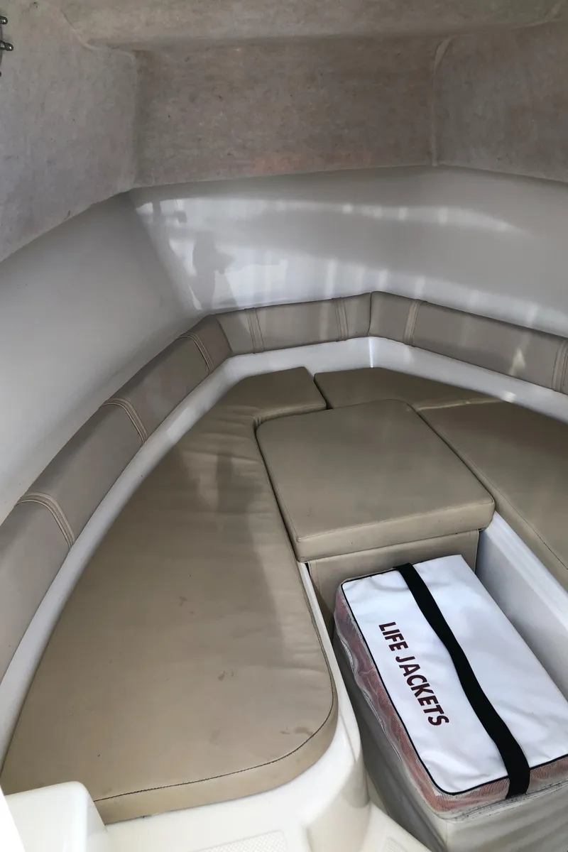 Slide: The Image of 2008 Key West 2300 Walkaround cabin interior with seating and life jackets. - 14