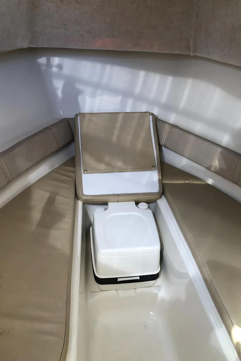 Slide: The Image of 2008 Key West 2300 Walkaround cabin interior with seating and portable toilet. - 15