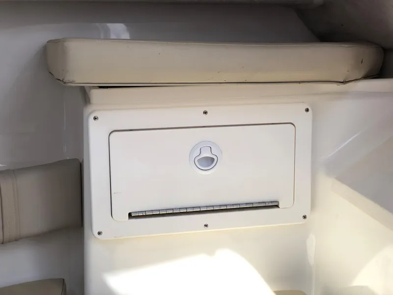 Slide: The Image of 2008 Key West 2300 Walkaround boat interior storage compartment with cushioned seating. - 16