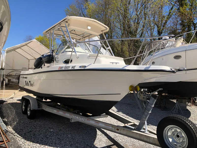 Slide: The Image of 2008 Key West 2300 Walkaround boat on trailer, parked outdoors under clear blue sky. - 3