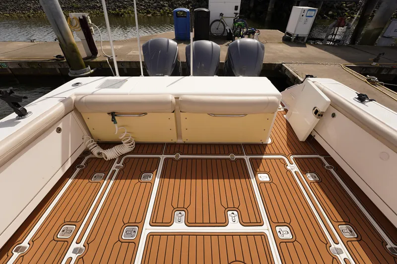 Slide: The Image of 2015 Pursuit OS 385 Offshore boat deck with twin engines at dock. - 11
