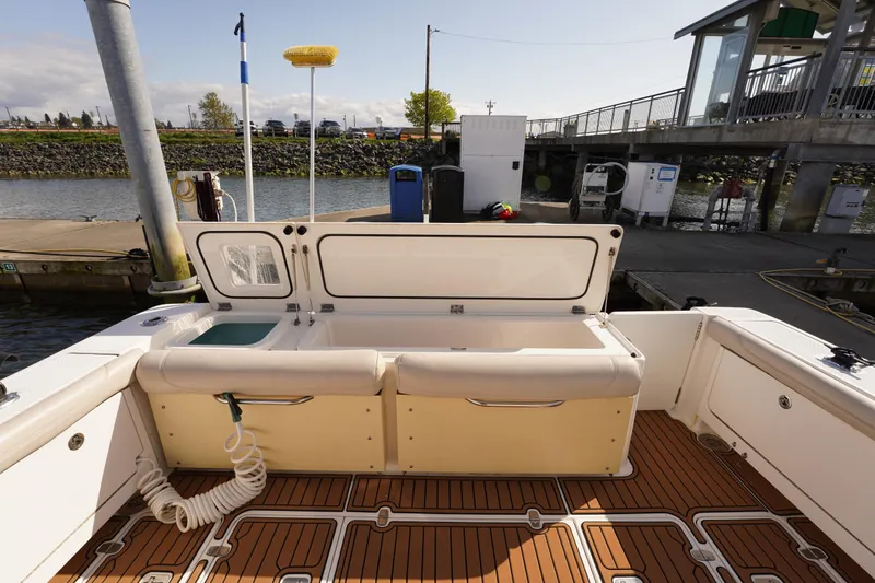 Slide: The Image of 2015 Pursuit OS 385 Offshore boat interior at dock, featuring open storage compartments. - 12