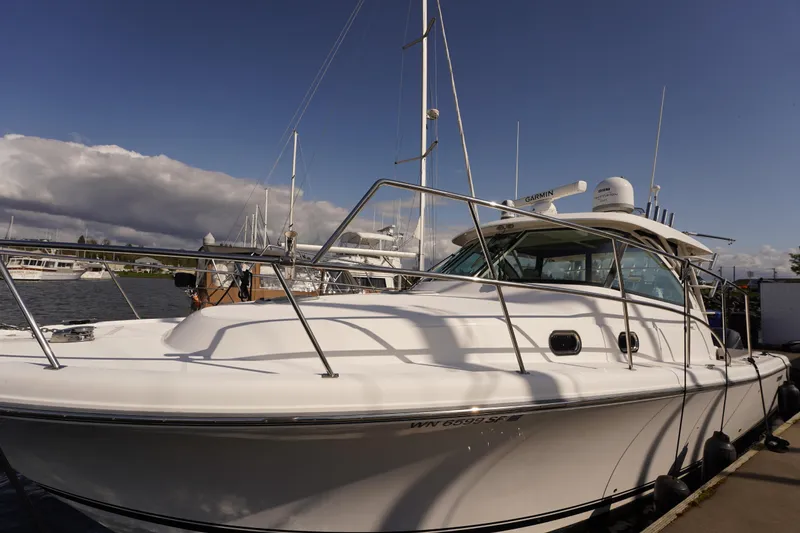 Slide: The Image of 2015 Pursuit OS 385 Offshore boat docked under a clear blue sky. - 2