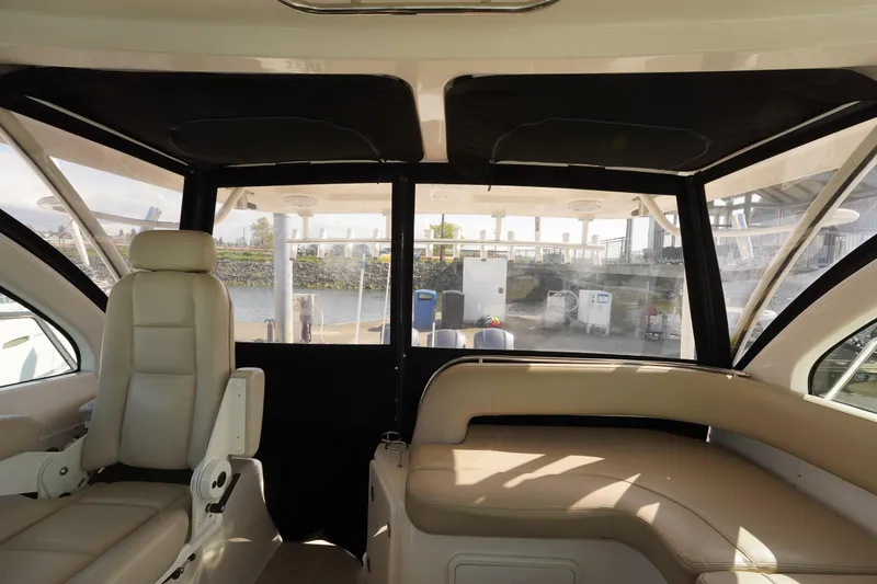 Slide: The Image of Interior of 2015 Pursuit OS 385 Offshore boat with beige seating and large windows. - 22