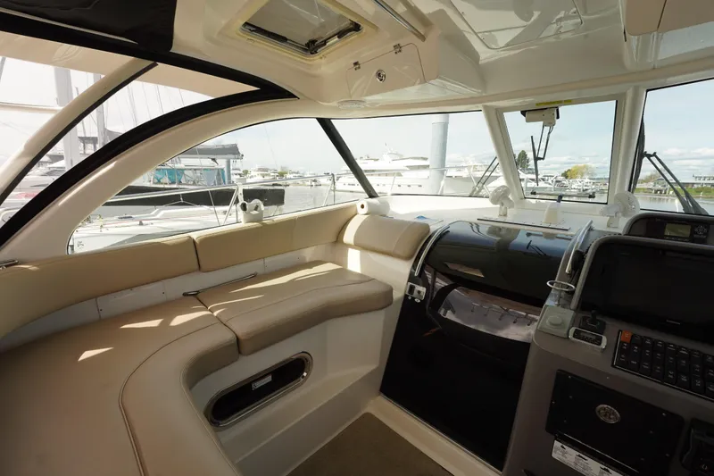 Slide: The Image of 2015 Pursuit OS 385 Offshore boat interior with beige seating and modern dashboard. - 24