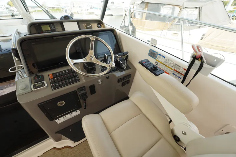 Slide: The Image of 2015 Pursuit OS 385 Offshore helm with steering wheel and navigation controls. - 26
