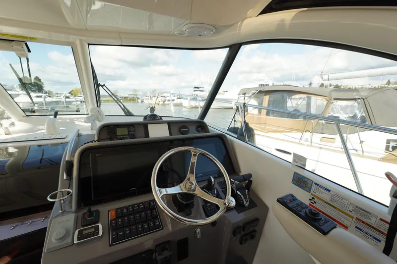 Slide: The Image of 2015 Pursuit OS 385 Offshore helm with steering wheel and navigation controls. - 27