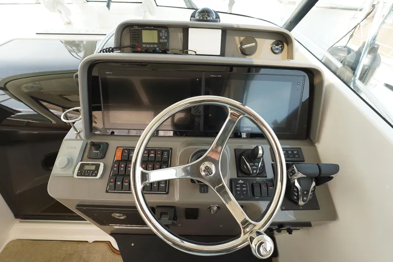 Slide: The Image of Helm of 2015 Pursuit OS 385 Offshore boat with steering wheel and navigation controls. - 28