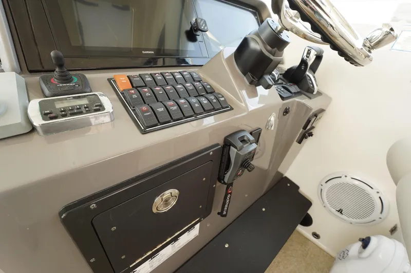 Slide: The Image of Control panel of a 2015 Pursuit OS 385 Offshore boat, featuring navigation and steering equipment. - 29