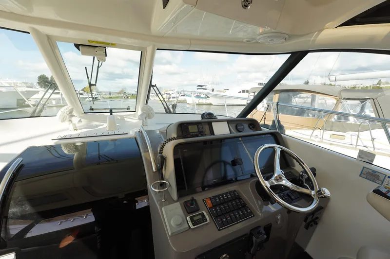 Slide: The Image of Helm of 2015 Pursuit OS 385 Offshore boat with steering wheel and navigation controls. - 32