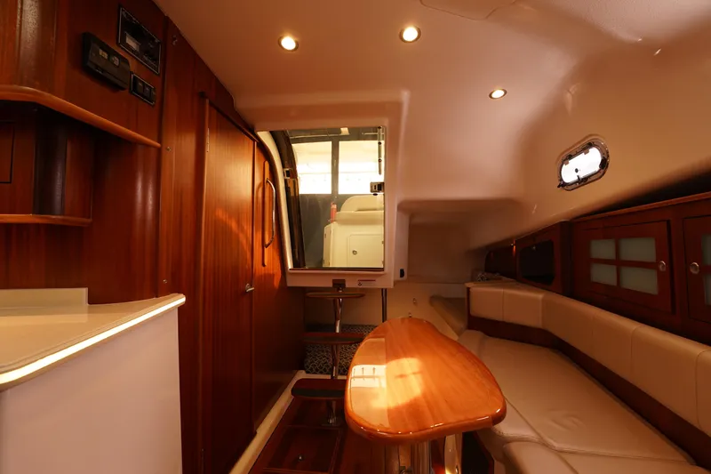 Slide: The Image of Luxurious interior of 2015 Pursuit OS 385 Offshore boat with wood finishes and seating area. - 34