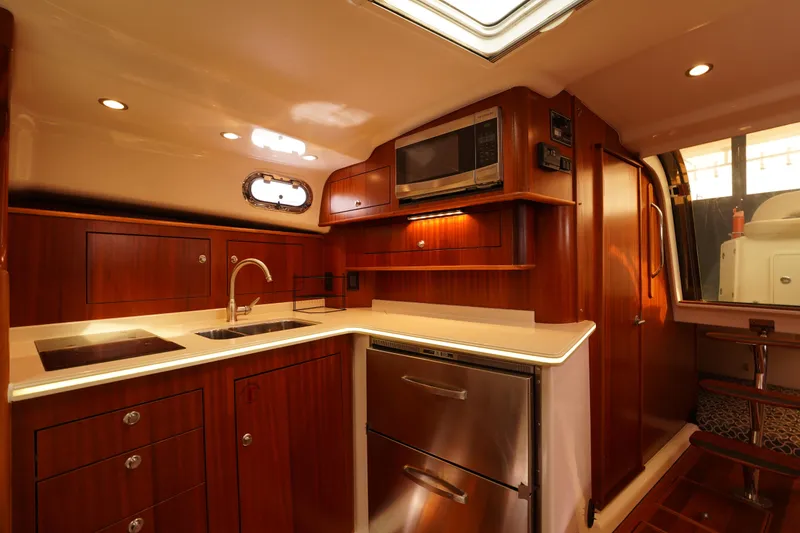 Slide: The Image of Luxurious 2015 Pursuit OS 385 Offshore yacht kitchen with wood cabinetry and modern appliances. - 35