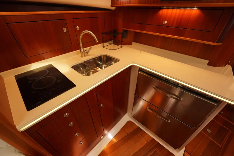 Slide: The Image of Luxurious 2015 Pursuit OS 385 Offshore yacht kitchen with wood cabinetry and modern appliances. - 37