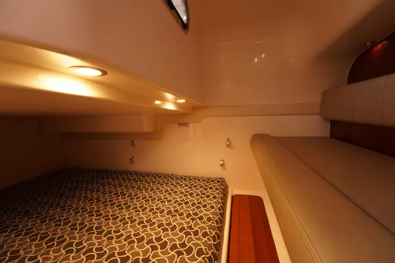 Slide: The Image of 2015 Pursuit OS 385 Offshore cabin interior with patterned bedding and ambient lighting. - 43