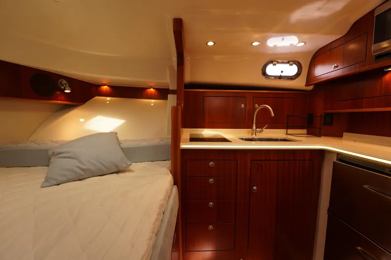 Slide: The Image of Luxurious interior of 2015 Pursuit OS 385 Offshore yacht with cozy bed and modern kitchenette. - 49