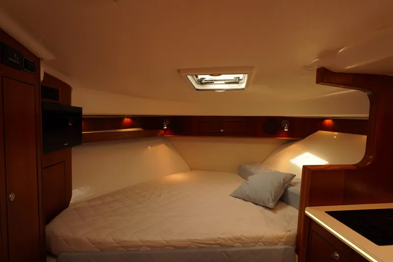 Slide: The Image of 2015 Pursuit OS 385 Offshore cabin interior with bed, wooden cabinetry, and ambient lighting. - 50