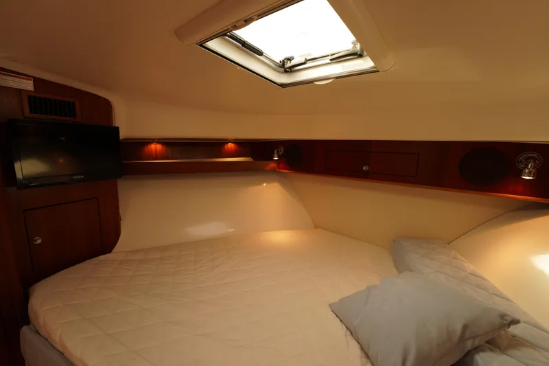 Slide: The Image of 2015 Pursuit OS 385 Offshore cabin interior with bed, TV, and skylight. - 51