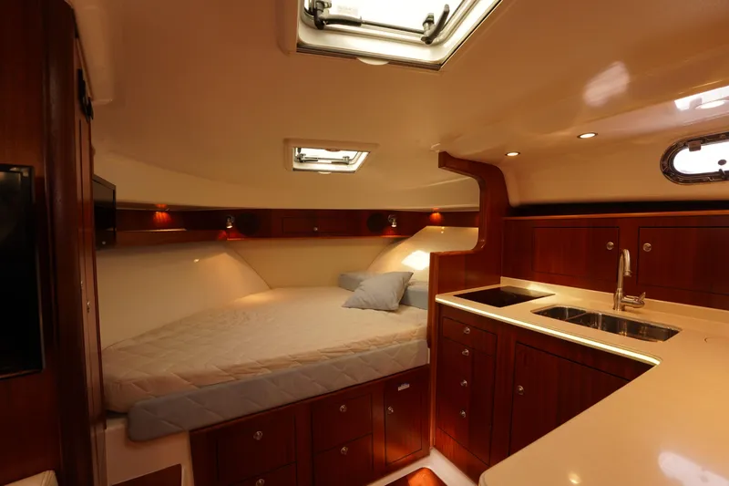 Slide: The Image of Luxurious cabin interior of 2015 Pursuit OS 385 Offshore yacht with bed and kitchenette. - 52