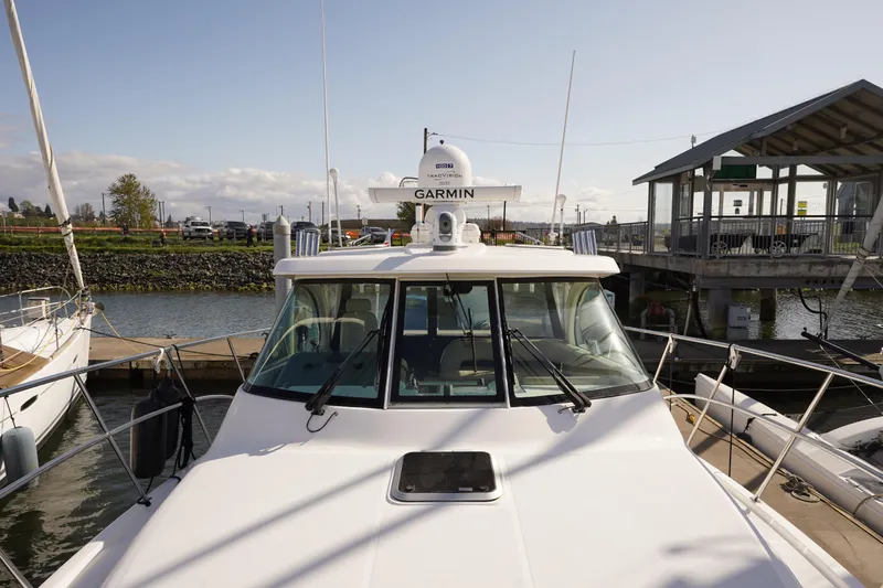 Slide: The Image of 2015 Pursuit OS 385 Offshore boat docked at marina with Garmin equipment. - 57
