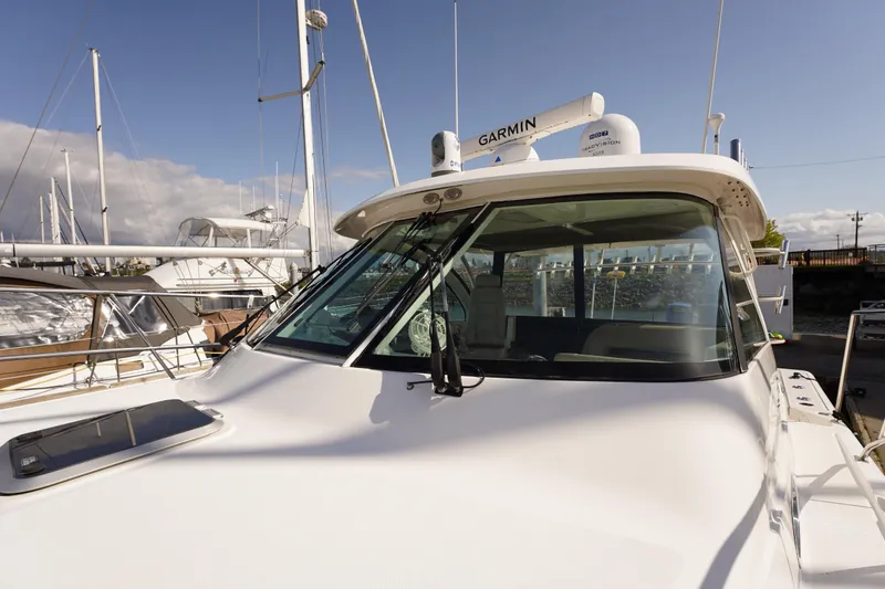 Slide: The Image of 2015 Pursuit OS 385 Offshore boat docked, featuring Garmin navigation equipment. - 58