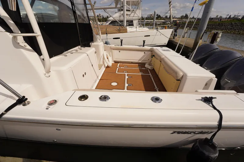 Slide: The Image of 2015 Pursuit OS 385 Offshore boat with spacious deck and seating at the marina. - 9