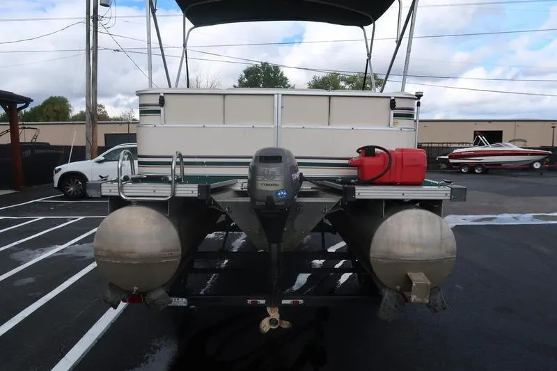 Slide: The Image of 1999 Starcraft Starfish 180 pontoon boat with outboard motor, parked in a lot. - 4