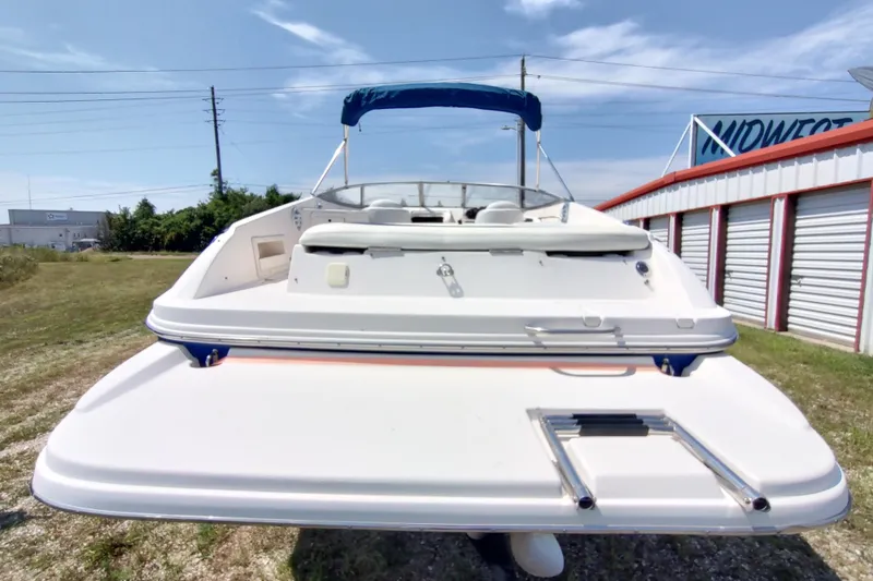 Slide: The Image of 2005 Rinker 232 Captiva Cuddy boat with swim platform and ladder, parked outdoors. - 18