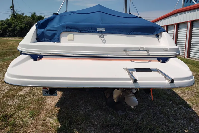 Slide: The Image of 2005 Rinker 232 Captiva Cuddy boat with blue cover, rear view. - 4