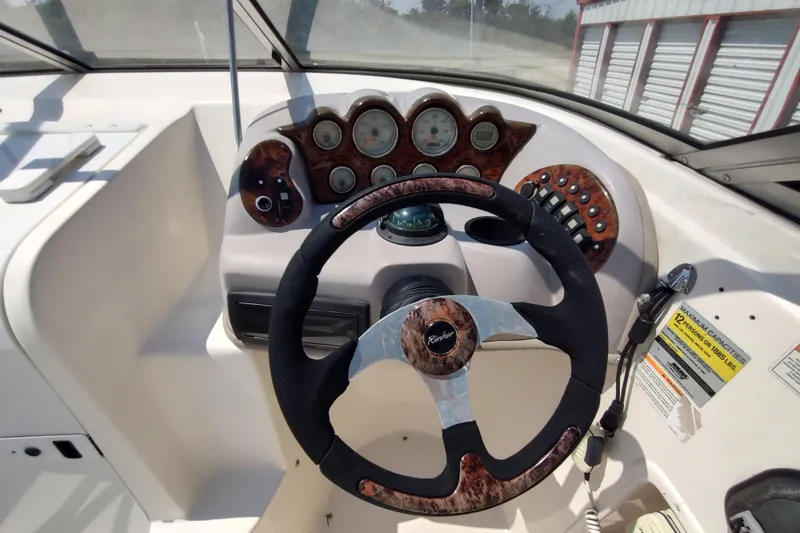 Slide: The Image of 2005 Rinker 232 Captiva Cuddy dashboard with steering wheel and instrument panel. - 9