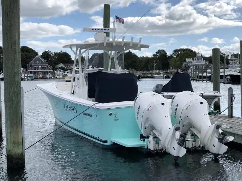Slide: The Image of 2018 Regulator 31 boat docked with twin Yamaha engines, under a cloudy sky. - 11