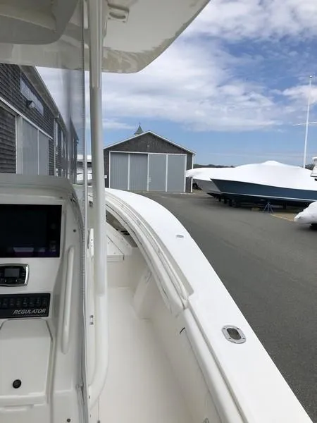 Slide: The Image of 2018 Regulator 31 boat docked near storage sheds under a partly cloudy sky. - 17