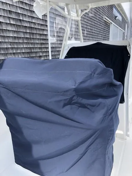 Slide: The Image of 2018 Regulator 31 boat with protective covers, docked near a shingled building. - 18