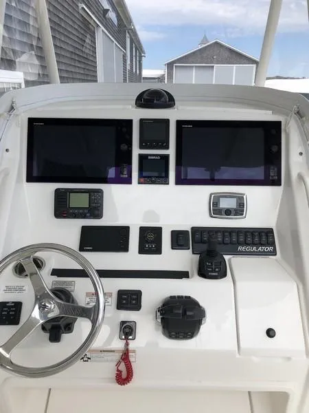 Slide: The Image of 2018 Regulator 31 boat dashboard with dual screens and navigation controls. - 14