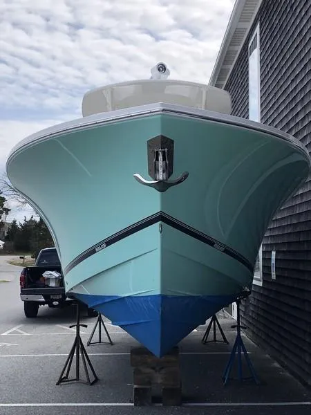 Slide: The Image of 2018 Regulator 31 boat on stands, parked beside a building. - 3