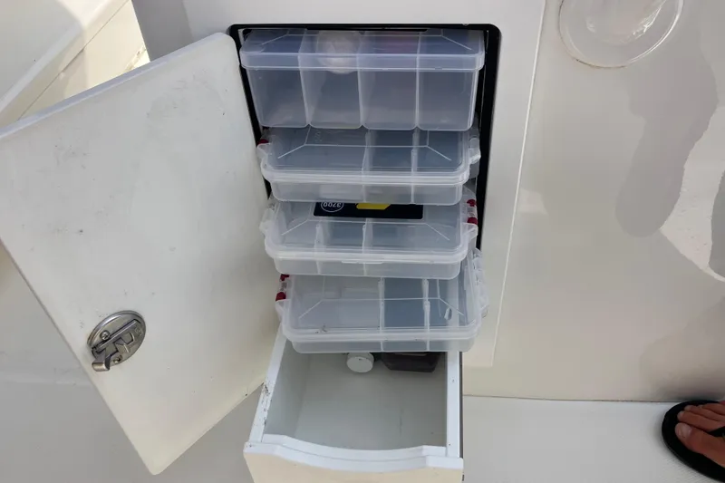 Slide: The Image of Storage compartment with clear plastic boxes on a 2020 Regulator 31 boat. - 10