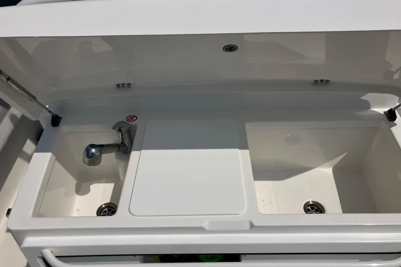 Slide: The Image of 2020 Regulator 31 boat sink and storage compartments, open lid view. - 12