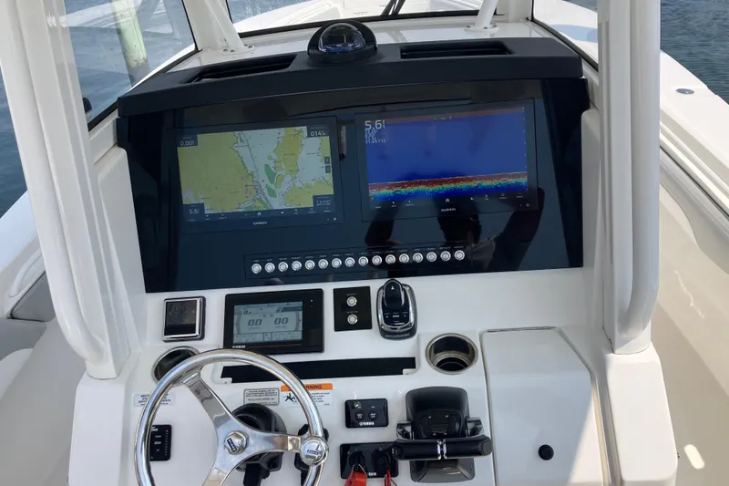 Slide: The Image of 2020 Regulator 31 boat dashboard with navigation screens and steering wheel. - 16