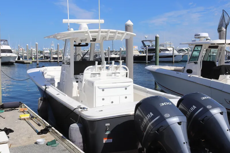 Slide: The Image of 2020 Regulator 31 boat docked with twin Yamaha 300 engines, marina background. - 2
