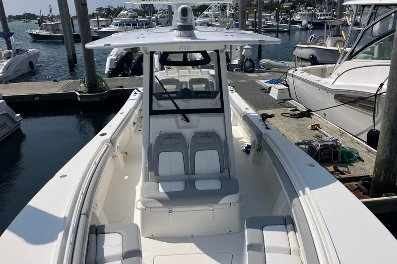 Slide: The Image of 2020 Regulator 31 boat docked at marina, featuring spacious seating and modern design. - 24