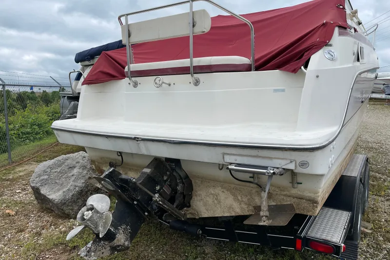 Slide: The Image of 1992 Maxum 2300 SC boat with red cover, on trailer, showing stern and propeller. - 14