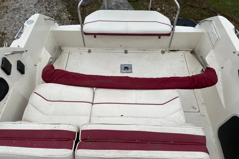 Slide: The Image of 1992 Maxum 2300 SC boat interior with white and red seating, showing wear. - 6