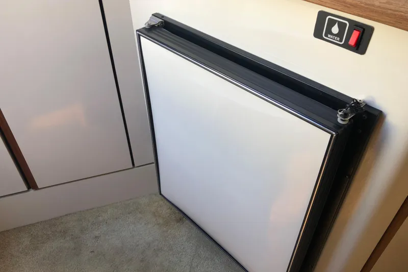 Slide: The Image of Interior of 1992 Maxum 2300 SC boat showing a compact refrigerator and water switch. - 8