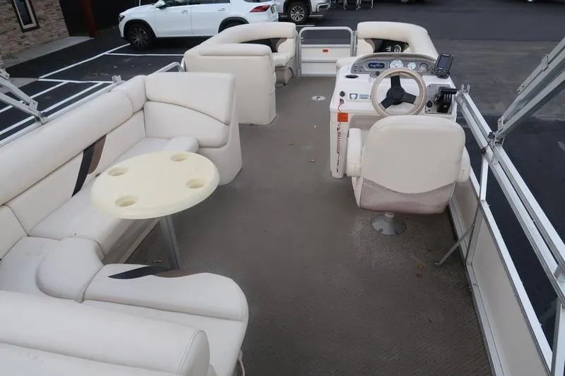Slide: The Image of 2010 Smoker Craft Sunchaser 8522 pontoon boat interior with beige seating and steering console. - 17