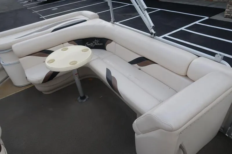 Slide: The Image of 2010 Smoker Craft Sunchaser 8522 boat interior with beige seating and round table. - 19