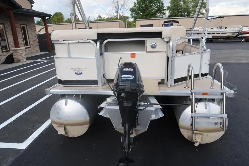 Slide: The Image of 2010 Smoker Craft Sunchaser 8522 pontoon boat with outboard motor, parked on asphalt. - 6