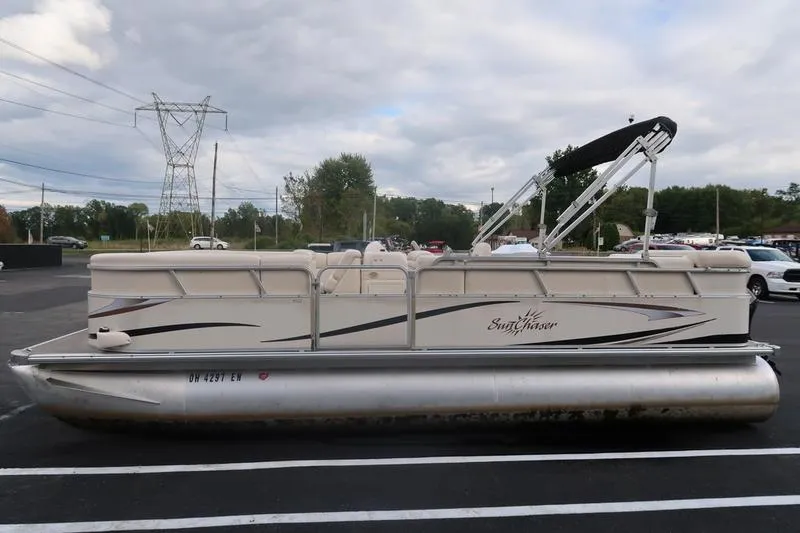 Slide: The Image of 2010 Smoker Craft Sunchaser 8522 pontoon boat in parking lot, side view. - 8