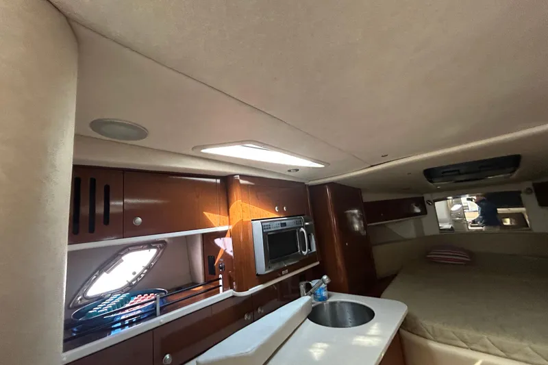 Slide: The Image of Interior of 2008 Sea Ray 330 Sundancer with kitchenette and cozy sleeping area. - 11